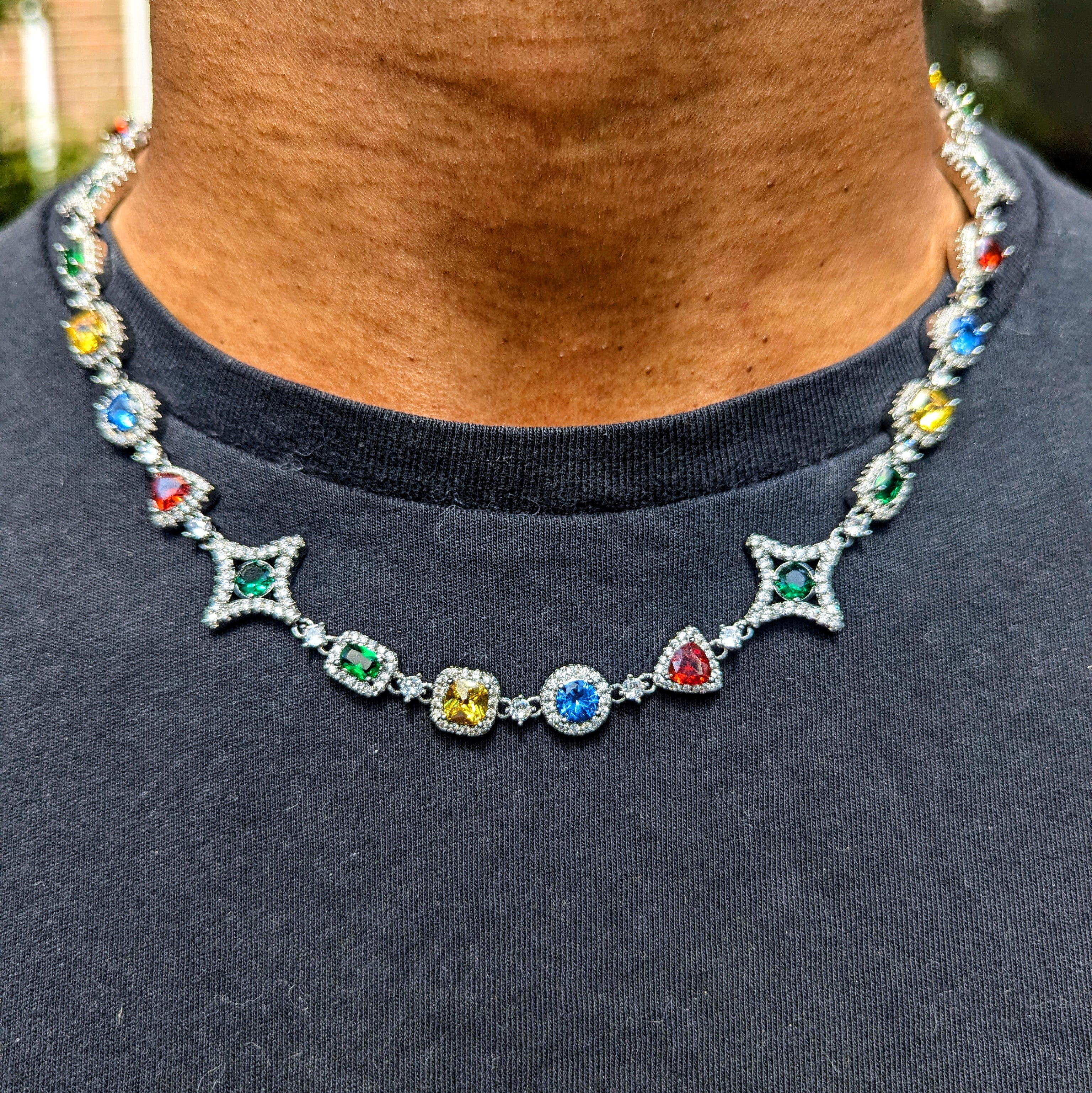 Necklace with colorful gemstones worn by a person on a dark shirt