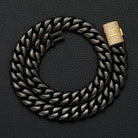 Black chain bracelet with a gold clasp on a dark textured background