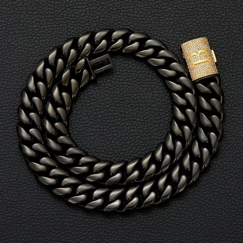 Black chain bracelet with a gold clasp on a dark textured background