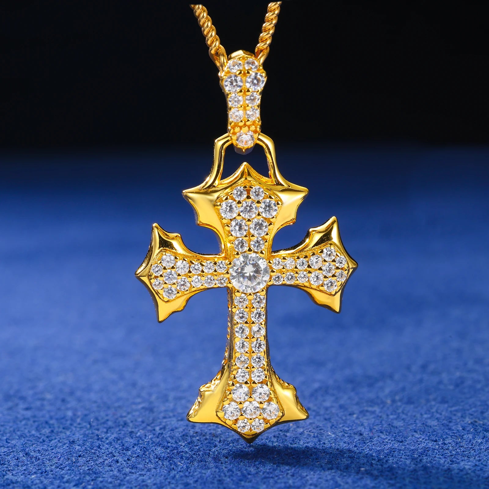Gold cross pendant with diamonds on a blue background