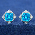 Pair of earrings with blue gemstones on a blue background