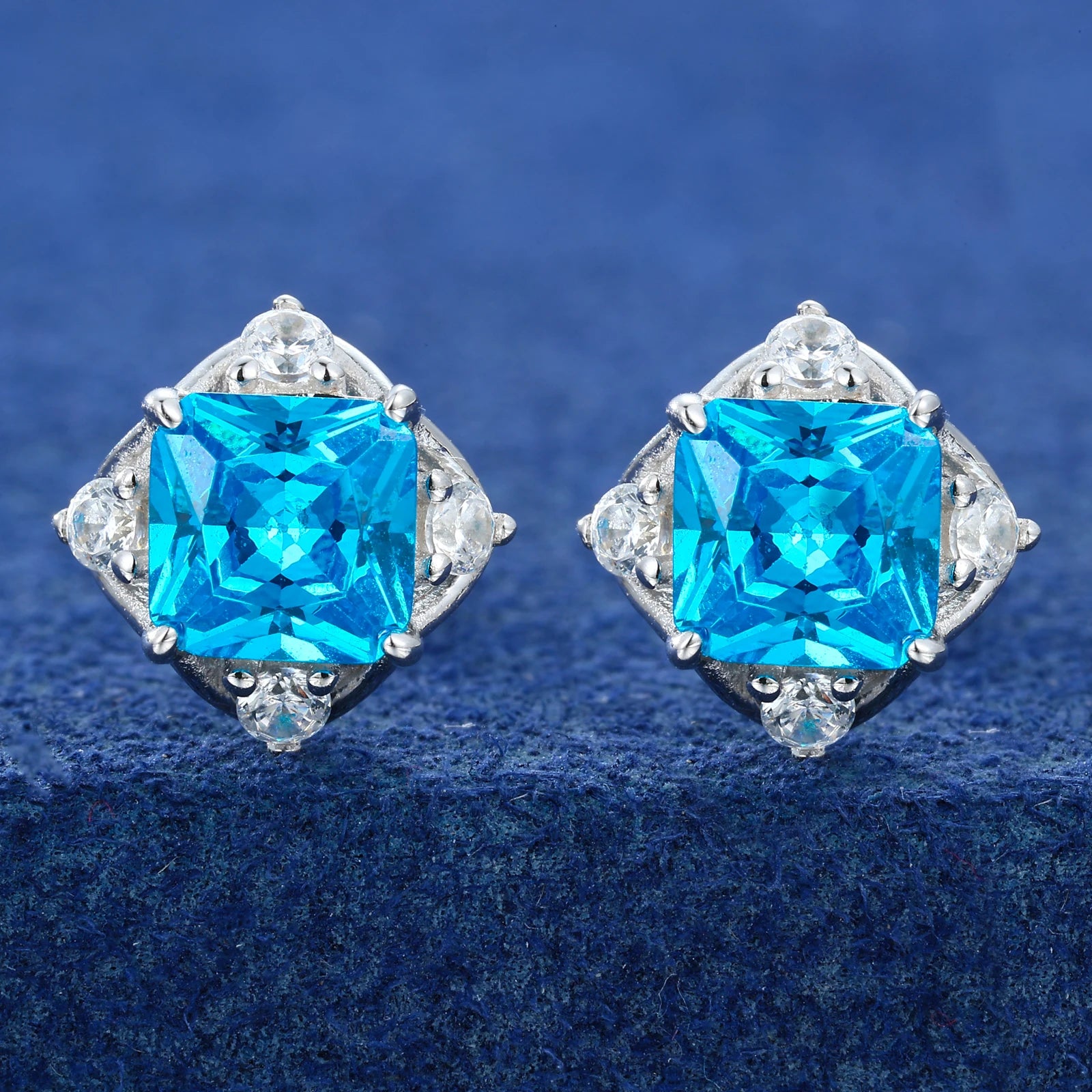 Pair of earrings with blue gemstones on a blue background